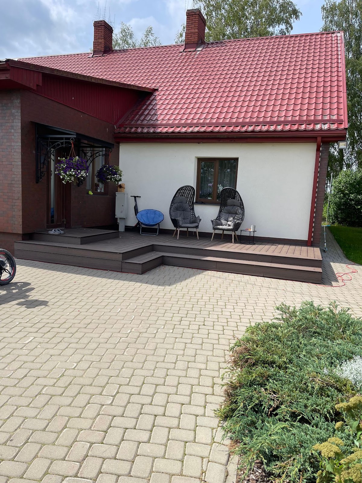Pabeigta mūra māja ar sarkanu jumtu un sakārtotu pagalmu kā stipras pamatnes rezultāts